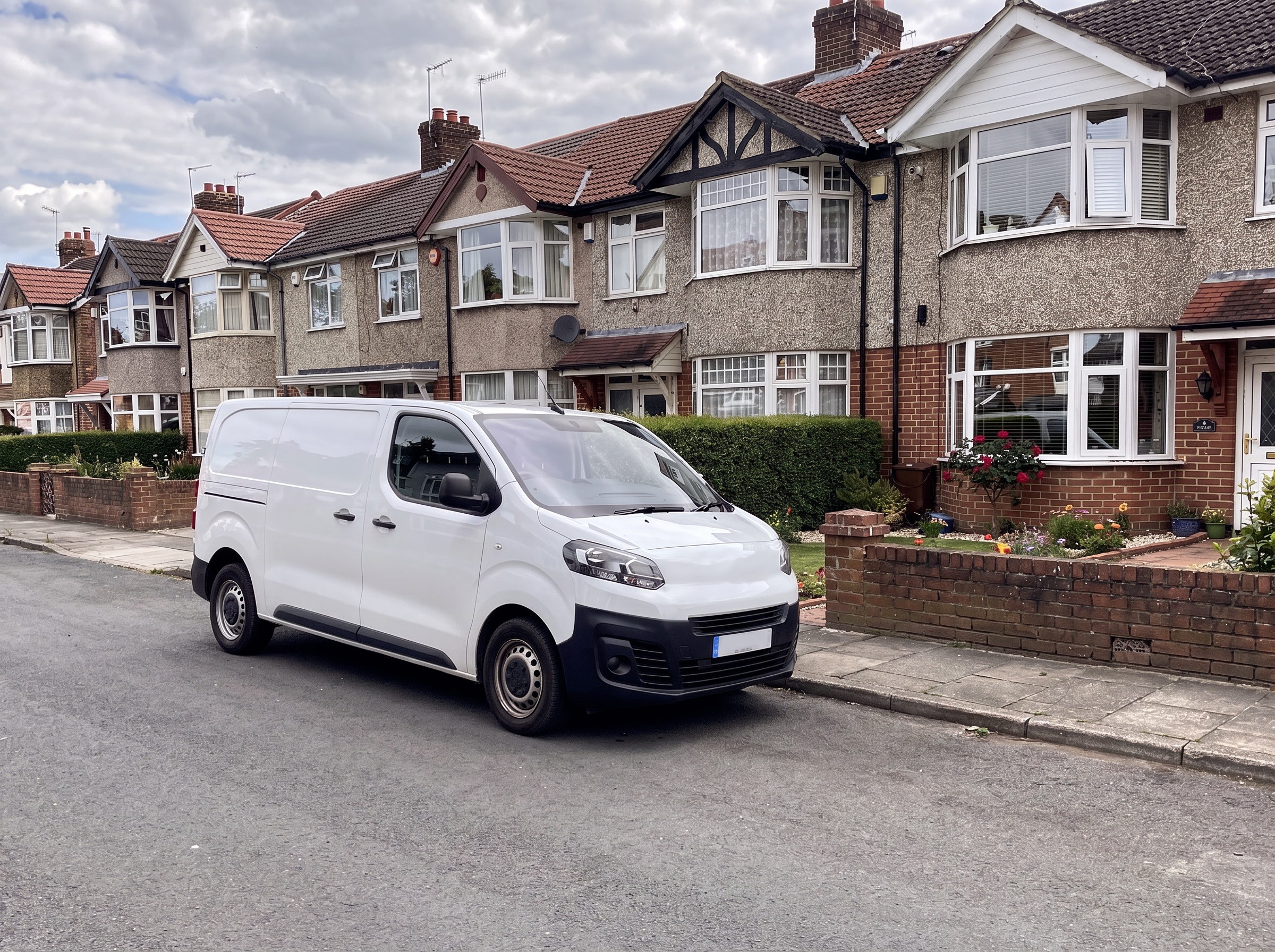 A white van parked outside a row of 1930s semi-detached houses
